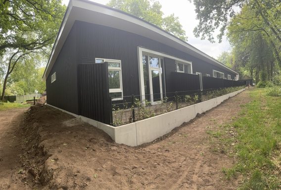 Houten aanbouw – zijaanzicht Zwarte houten aanbouw met ramen en deuren